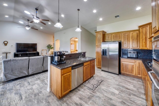 kitchen featuring lofted ceiling, sink, tasteful backsplash, appliances with stainless steel finishes, and pendant lighting