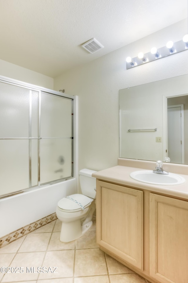 full bathroom featuring toilet, a textured ceiling, vanity, enclosed tub / shower combo, and tile patterned flooring