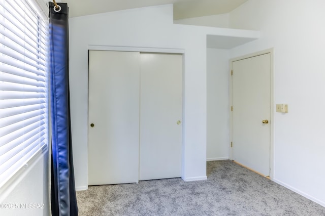 unfurnished bedroom with light carpet and a closet