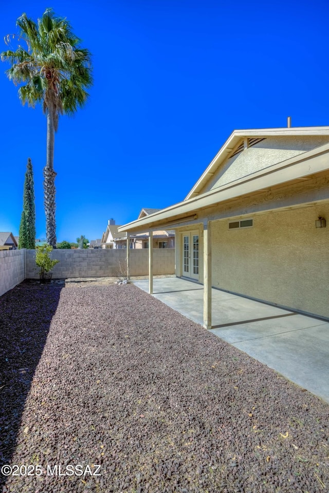 view of yard featuring a patio and french doors