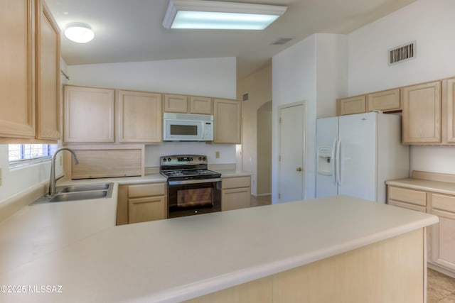 kitchen with white appliances, lofted ceiling, light brown cabinetry, and sink