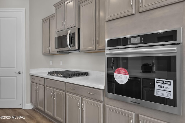 kitchen featuring light stone counters, hardwood / wood-style flooring, and appliances with stainless steel finishes