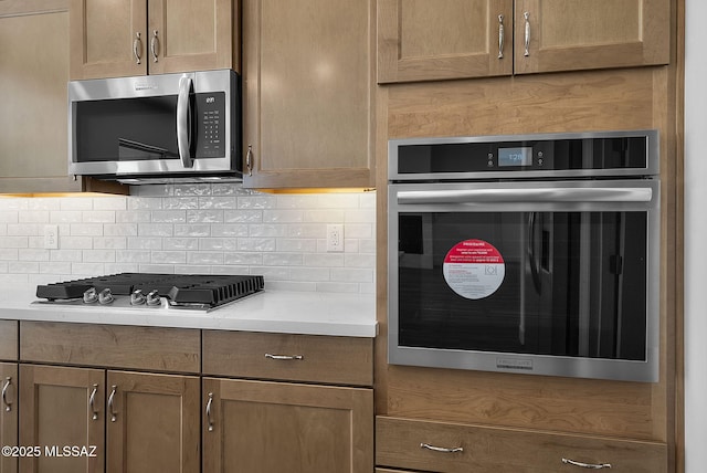 kitchen featuring stainless steel appliances and tasteful backsplash
