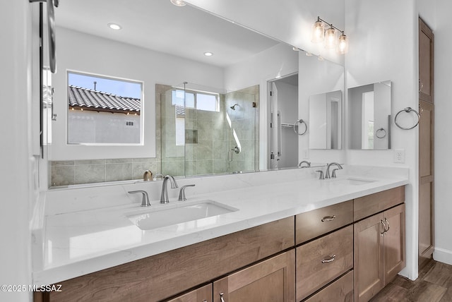 bathroom featuring wood-type flooring, walk in shower, and vanity