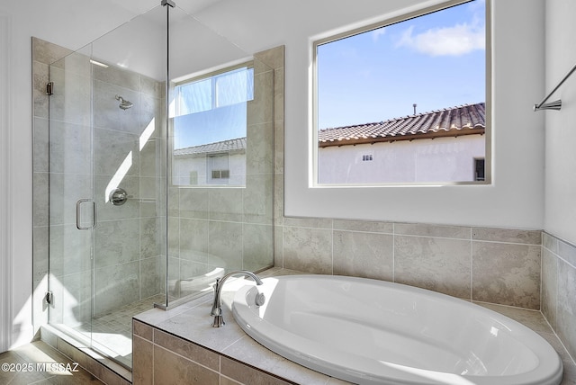 bathroom featuring separate shower and tub
