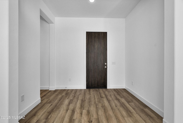 unfurnished room with dark wood-type flooring