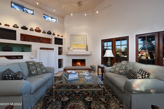 living room with built in features and a towering ceiling