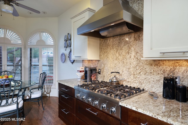 kitchen with stainless steel gas stovetop, white cabinetry, tasteful backsplash, light stone countertops, and range hood