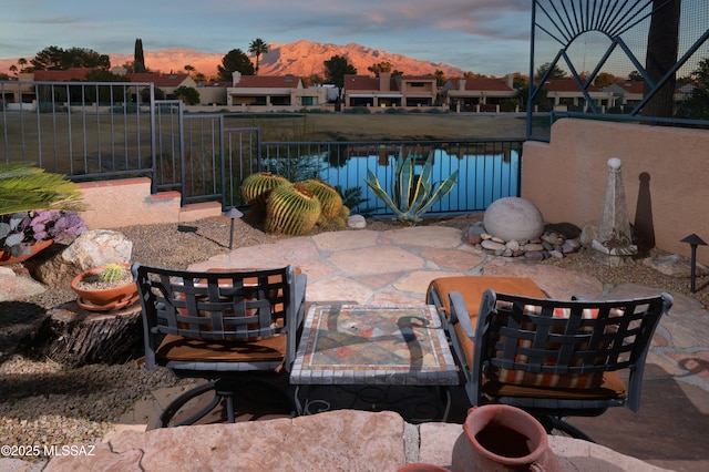 patio terrace at dusk featuring a mountain view