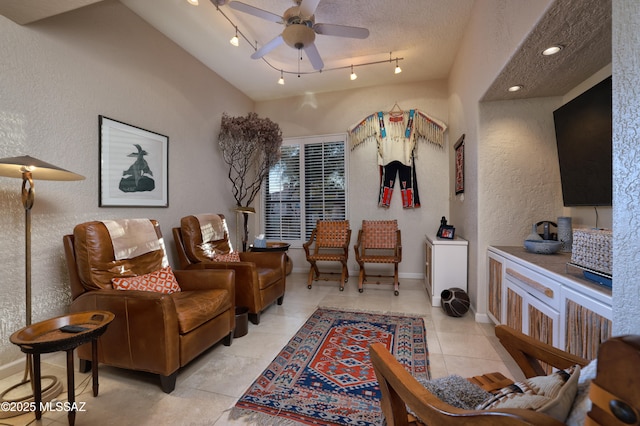 living room with ceiling fan, light tile patterned floors, track lighting, and a textured ceiling