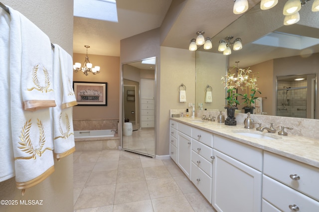 bathroom featuring tile patterned floors, vanity, a chandelier, and separate shower and tub