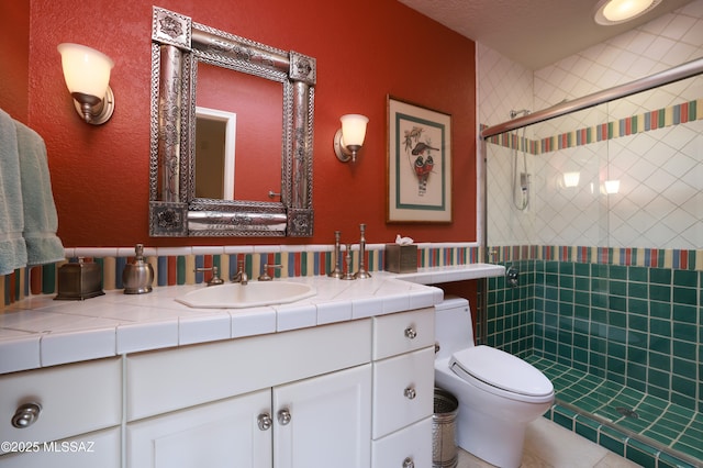 bathroom with toilet, vanity, and a shower with door