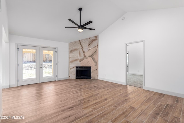 unfurnished living room featuring ceiling fan, french doors, a high end fireplace, and light hardwood / wood-style floors