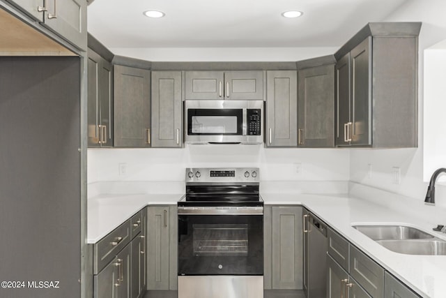 kitchen featuring appliances with stainless steel finishes, gray cabinetry, and sink