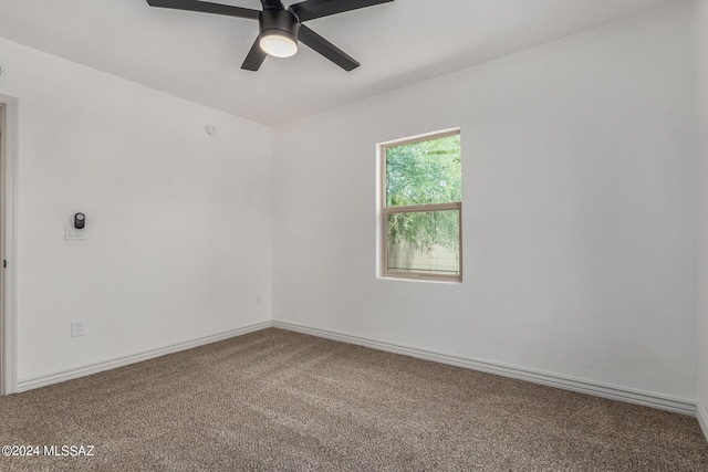 empty room featuring ceiling fan and carpet