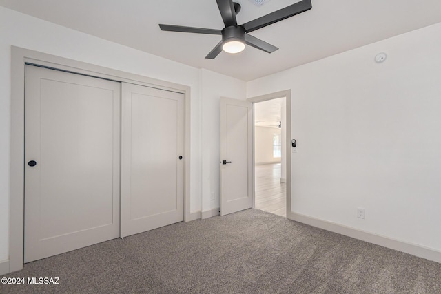 unfurnished bedroom featuring light carpet, ceiling fan, and a closet