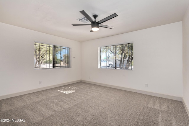 carpeted empty room with ceiling fan and a healthy amount of sunlight