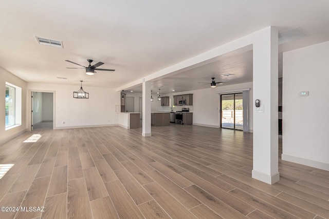 unfurnished living room with ceiling fan and hardwood / wood-style floors