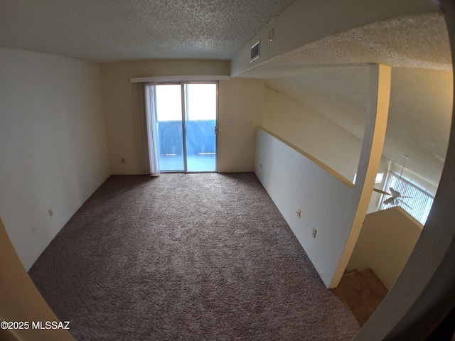 carpeted empty room with a textured ceiling