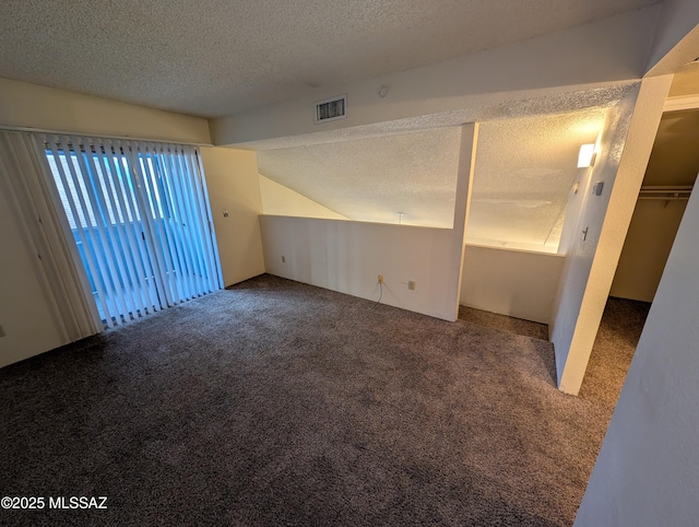 spare room with carpet, lofted ceiling, and a textured ceiling