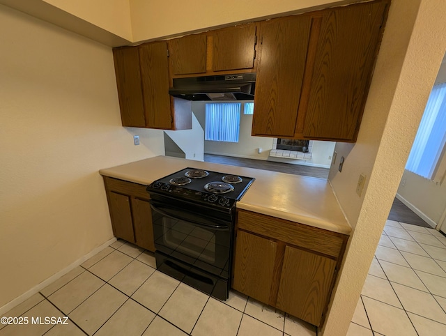 kitchen featuring black range with electric stovetop, a wealth of natural light, and light tile patterned flooring