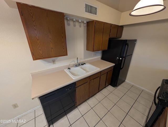 kitchen featuring sink, light tile patterned floors, and black appliances