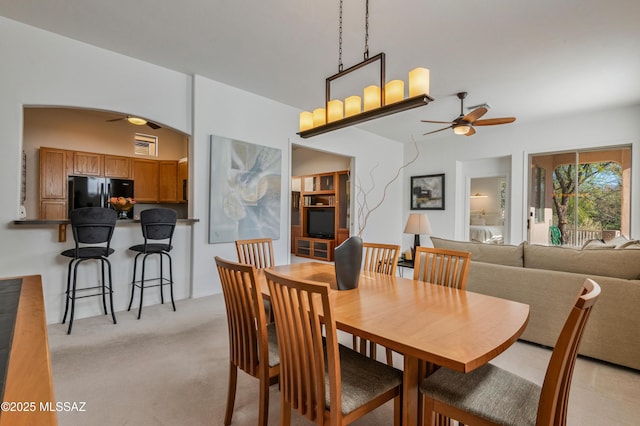 dining room with ceiling fan and light colored carpet