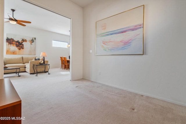 interior space featuring light carpet and ceiling fan