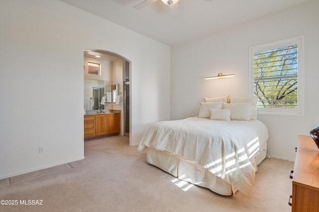 carpeted bedroom featuring ensuite bathroom and ceiling fan