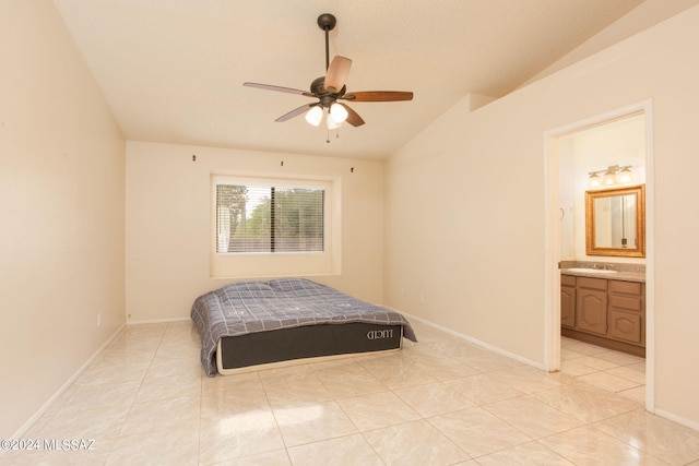 bedroom featuring vaulted ceiling, ensuite bath, ceiling fan, sink, and light tile patterned flooring