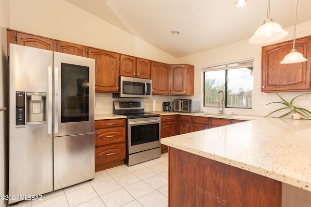 kitchen featuring sink, vaulted ceiling, hanging light fixtures, light stone countertops, and appliances with stainless steel finishes