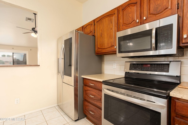 kitchen with ceiling fan, stainless steel appliances, decorative backsplash, and light tile patterned floors