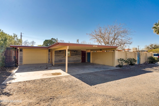 view of front of property featuring an attached garage, driveway, stone siding, and an attached carport