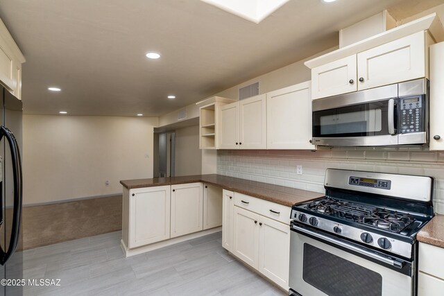 kitchen with stainless steel appliances, a sink, dark countertops, visible vents, and recessed lighting