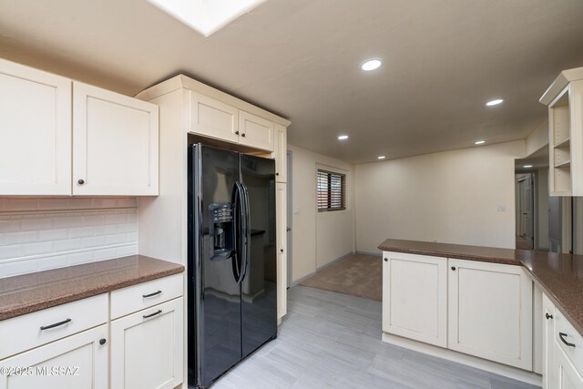 kitchen with stainless steel appliances, a peninsula, recessed lighting, and dark countertops
