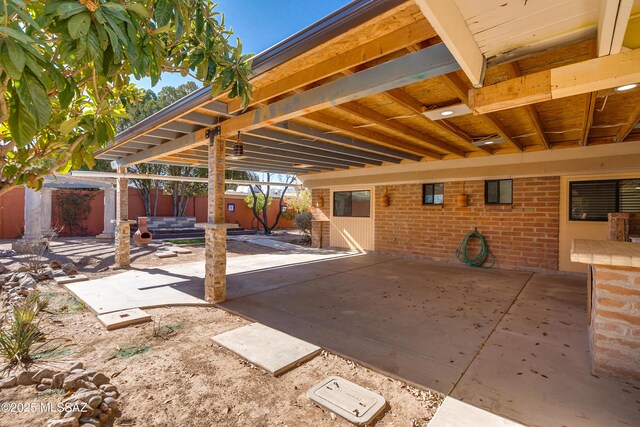 view of patio / terrace with fence and stacked washer and dryer