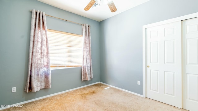 carpeted empty room featuring ceiling fan