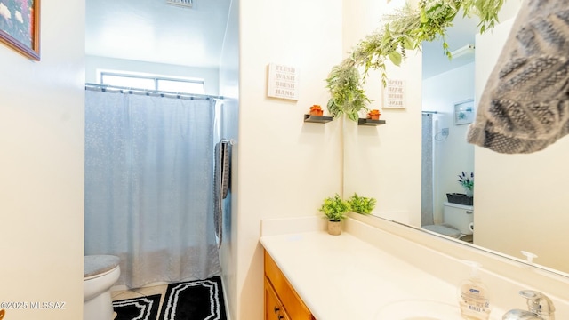 bathroom featuring toilet, vanity, tile patterned floors, and curtained shower