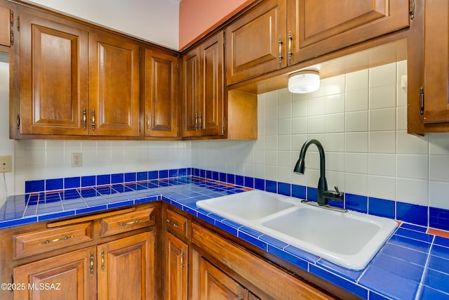 kitchen featuring sink, tile countertops, and decorative backsplash