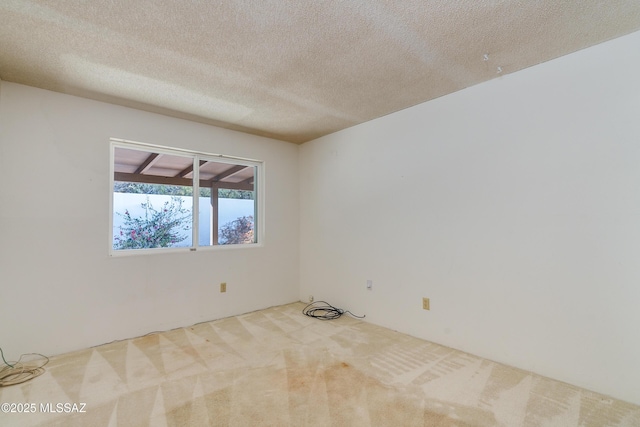 carpeted spare room with a textured ceiling