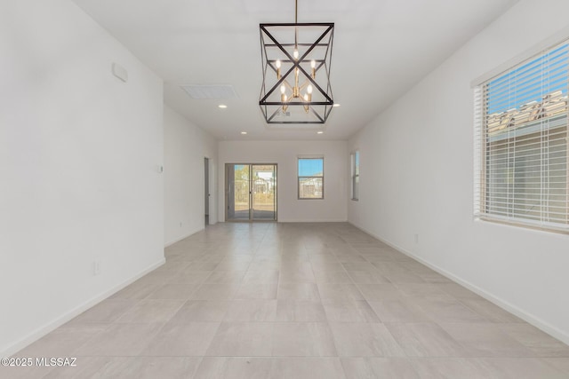 tiled empty room with a chandelier