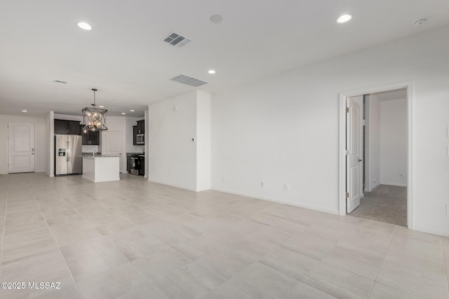 unfurnished living room with light tile patterned floors and a notable chandelier