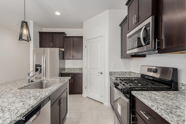 kitchen with sink, hanging light fixtures, stainless steel appliances, light tile patterned floors, and light stone counters