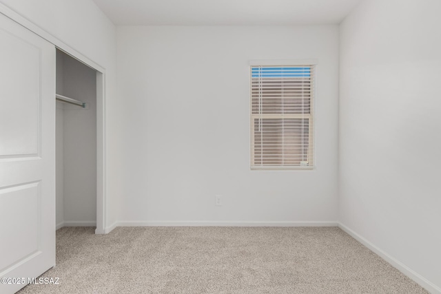 unfurnished bedroom featuring a closet and light carpet