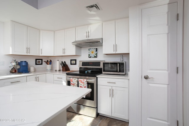 kitchen with dark wood-type flooring, stainless steel appliances, and white cabinets