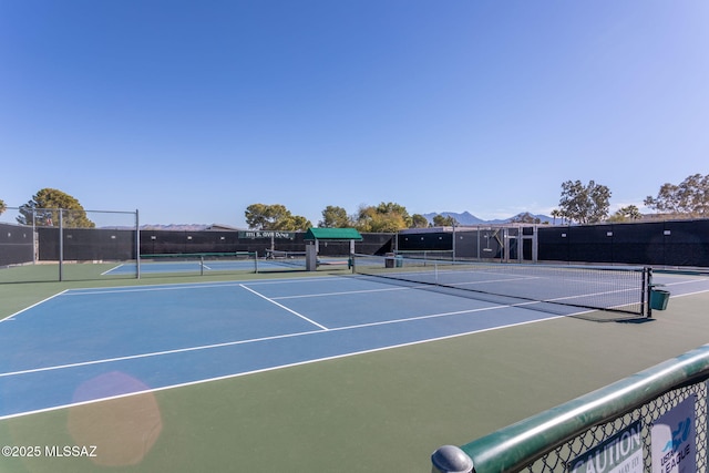 view of tennis court with basketball hoop