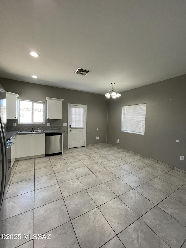 kitchen with a notable chandelier, stainless steel dishwasher, sink, light tile patterned flooring, and white cabinets