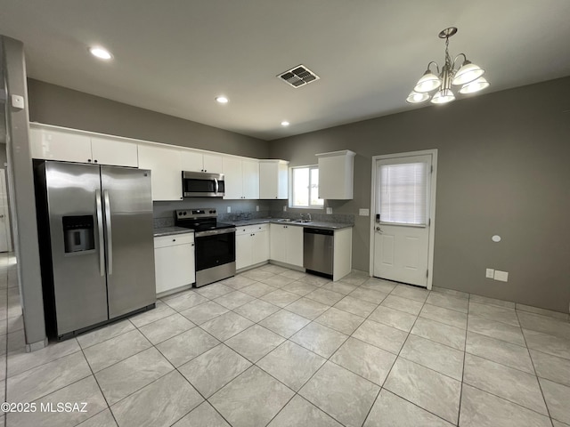 kitchen with pendant lighting, white cabinets, stainless steel appliances, a chandelier, and light tile patterned floors