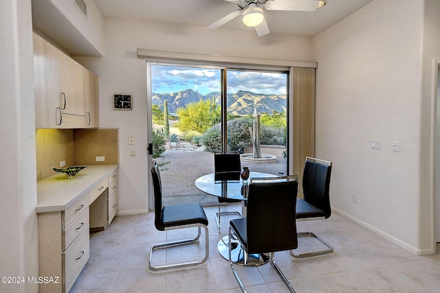 dining area with ceiling fan, light tile patterned floors, and a mountain view