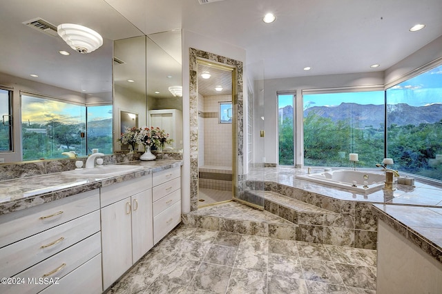 bathroom with a mountain view, separate shower and tub, and vanity